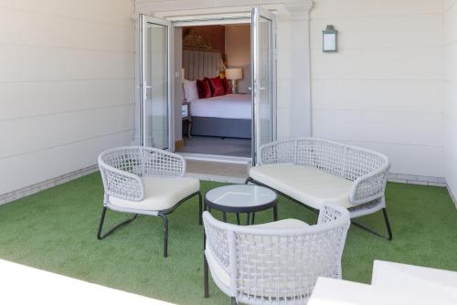 a room with two chairs and a table and a bed at Polo Club - Hotel in Ufton
