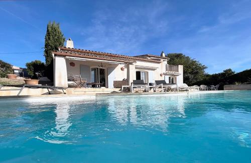 une maison avec une piscine devant dans l'établissement Les jasmins piscine proche mer jardin, à Saint-Raphaël