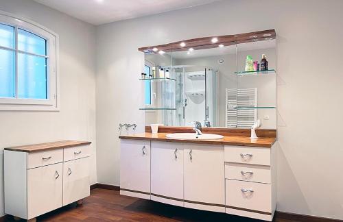 une salle de bain avec un lavabo et un miroir dans l'établissement Les jasmins piscine proche mer jardin, à Saint-Raphaël
