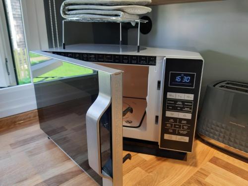 a microwave oven with its door open on a table at All Manor Of Events - Glamping Pods in Henley