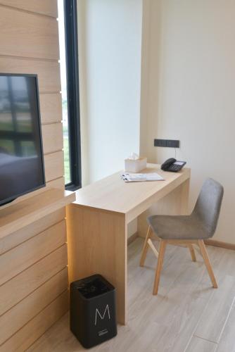 a desk with a chair and a television at Mayuu Ayutthaya Hotel in Ban Ko Rian