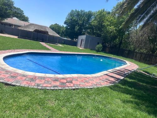 a swimming pool in a yard with a brick at Starpoint Guest house in Vereeniging