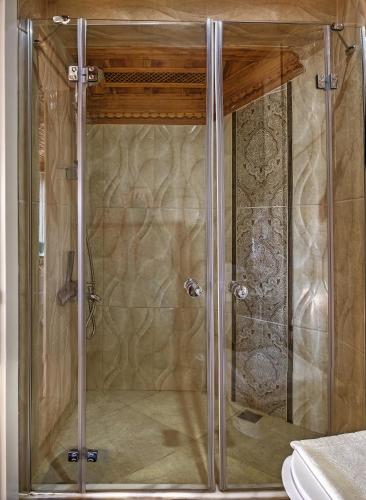 a shower with a glass door in a bathroom at Panamare Apart Hotel Akyaka in Akyaka