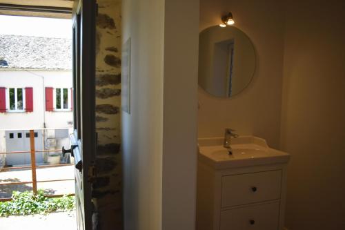 une salle de bain avec un lavabo, un miroir et une fenêtre dans l'établissement Les Carbonniers, à Saint-André-de-Najac