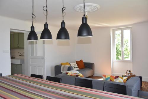 - un salon avec un canapé et des lampes suspendues dans l'établissement Les Carbonniers, à Saint-André-de-Najac
