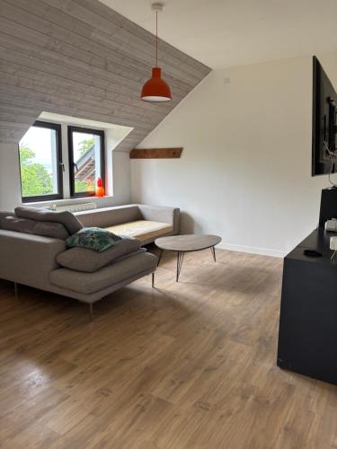 un salon avec un canapé et une table dans l'établissement Gîte des ravenelles, à Cricquebœuf