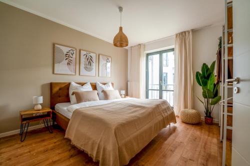 ein Schlafzimmer mit einem Bett und einem großen Fenster in der Unterkunft Luma-Living Apartments in Dresden