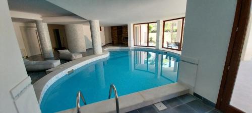 a large swimming pool with blue water in a building at Villa Giulia in Siracusa