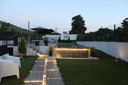 a backyard with a pool with lights on the grass at Casa do pato 2 in Peso da Régua