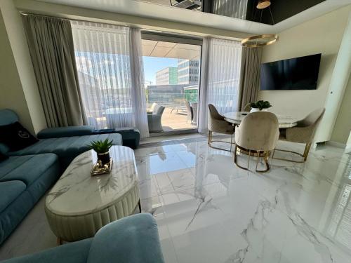 a living room with a blue couch and a table at Apartament Faltom 26 Yacht Park z tarasem in Gdynia