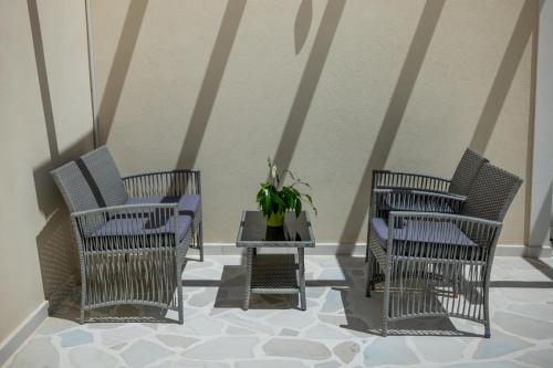 a group of chairs and a table with a potted plant at Aristides Cottage in Kassiopi