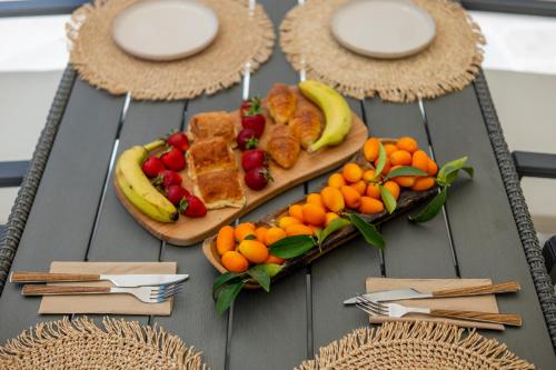 a table with two plates of food and fruit at Aristides Cottage in Kassiopi