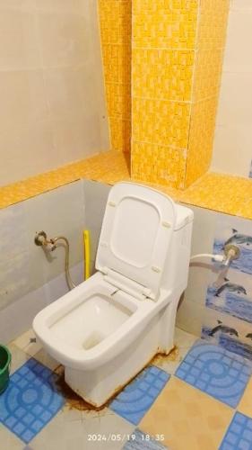 a bathroom with a white toilet in a room at The Misty Hotel in Bhatwāri