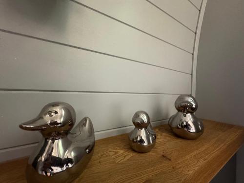 two metal birds sitting on a wooden shelf at All Manor Of Events - Glamping Pods in Henley