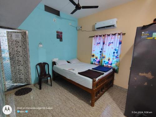 a small bedroom with a bed and a chair at DSouza Homestay in Māvalli