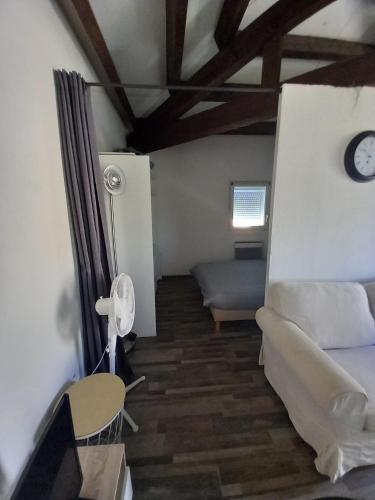 un salon avec un canapé et une horloge au mur dans l'établissement Superbe appartement terrasse piscine proche plage, au Barcarès