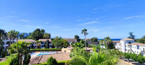 un complexe avec piscine et palmiers dans l'établissement Appt 4-6 couchages climatisé avec 2 piscines et 200 m des plages et criques, à Linguizzetta