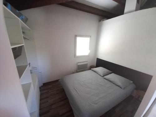 乐巴凯尔斯Superbe appartement terrasse piscine proche plage的一间带床和窗户的小卧室