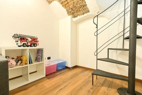una cameretta per bambini con una scala e un camion dei pompieri su uno scaffale di Nicma, a small candy box in the center a Torino