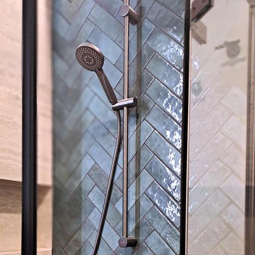a shower in a bathroom next to a glass door at Zakontek Lubkowa in Lubkowo