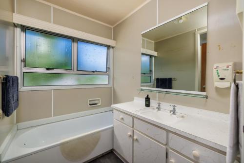 un bagno con lavandino e specchio di Te Tiriti Beach House - Paihia Holiday Home a Paihia