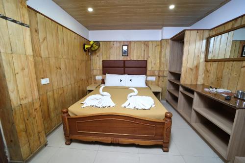 a bedroom with a bed with swans on it at Vivera Highlands in Kodaikānāl