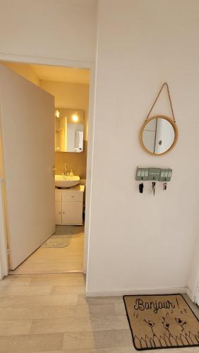 - un couloir avec un miroir et un lavabo dans la chambre dans l'établissement Acces direct à la mer proche thalasso, à Cabourg