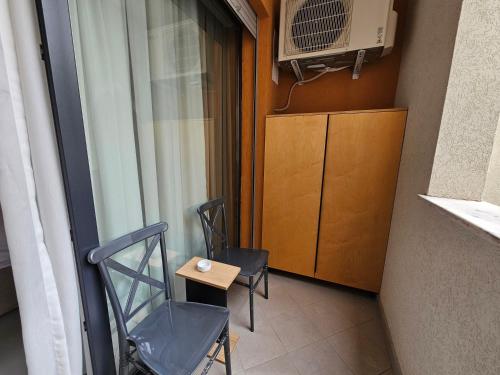 a balcony with two chairs and a table and a microwave at Valentino Noir in Tirana