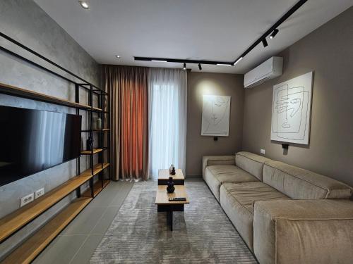 a living room with a couch and a large television at Valentino Noir in Tirana