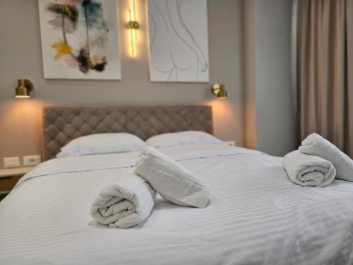 a white bed with towels on top of it at Valentino Noir in Tirana