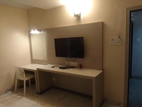a room with a desk with a television on a wall at SHIVANGAN HOTEL and BANQUET in kolkata