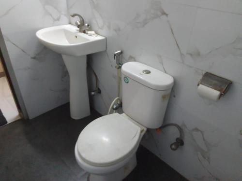 a bathroom with a white toilet and a sink at SHIVANGAN HOTEL and BANQUET in kolkata