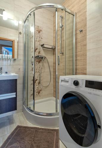 a washing machine in a bathroom with a shower at Platinium Wrzeszcz - Batorego in Gdańsk