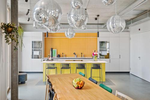 a kitchen with a wooden table and a yellow wall at Ariv Design Hotel Zug in Zug