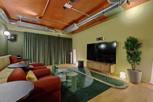 a living room with a flat screen tv and a couch at Ariv Design Hotel Zug in Zug