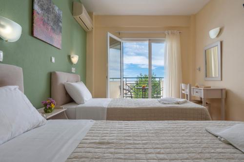 a hotel room with two beds and a balcony at Julia Hotel in Fourka