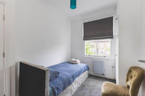a bedroom with a bed and a tv and a window at Stylish Flat B in London