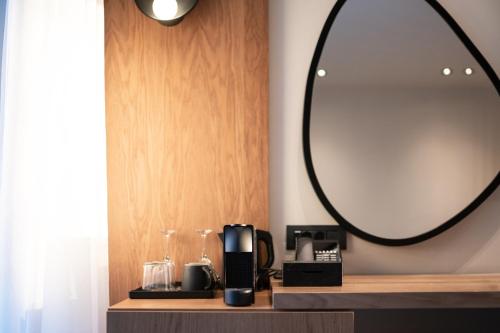 a bathroom with a mirror and a coffee maker on a shelf at Anna Island in Pefkohori
