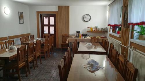a dining room with tables and chairs and a clock at "Gawęckówka u Jasia i Małgosi" Krynica Zdrój in Krzyżówka