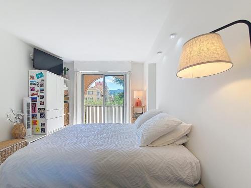 - une chambre blanche avec un lit et une lampe dans l'établissement Spacieux 4 pers ultra-centre, à Nice