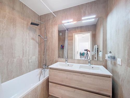 une salle de bain avec une baignoire, un lavabo et un miroir dans l'établissement Spacieux 4 pers ultra-centre, à Nice