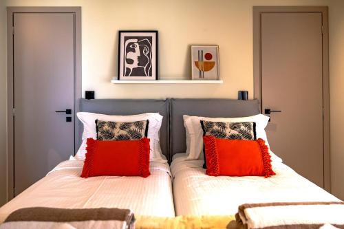 a bedroom with two beds with red and white pillows at Scalma Villas in Skaloma