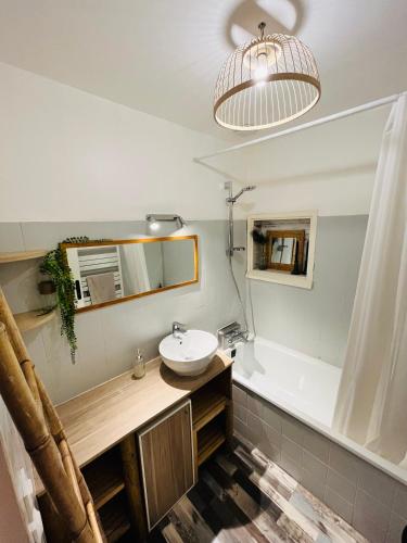 une salle de bain avec un lavabo et une baignoire dans l'établissement Maison avec piscine, à Angresse