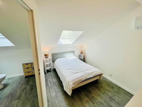 une chambre avec un lit et une lucarne dans l'établissement 2 suites, cour privée, climatisation, Le nid de Blois Vienne, à Blois