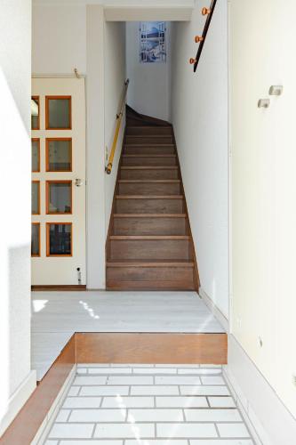 a staircase in a house with white walls and wooden floors at 1200IN&OUT 10people 75m2 8bed! Exclusive house Shinjuku 13 minutes Shibuya 19 minutesIkebukuro 8 minutes Ueno 9 minutes in Tokyo