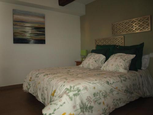 a bedroom with a bed with a comforter and pillows at Apartamento entreHoces Plaza Mayor in Cuenca