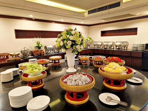 een tafel met borden en kommen met eten erop bij Royal Peninsula Hotel Chiangmai in Chiang Mai