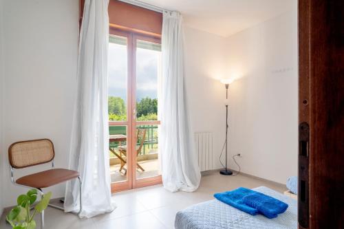 a bedroom with a bed and a window with a balcony at Modern Beach Apartment Near Forte dei Marmi in Marina di Massa