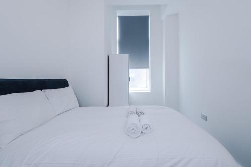 a white bed with two towels on top of it at Cohost Partners Cozy Stay Heart of Warrington in Warrington
