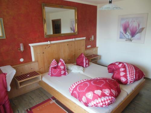 a bed with pink pillows on it in a room at Pension Sonnhof in Radstadt